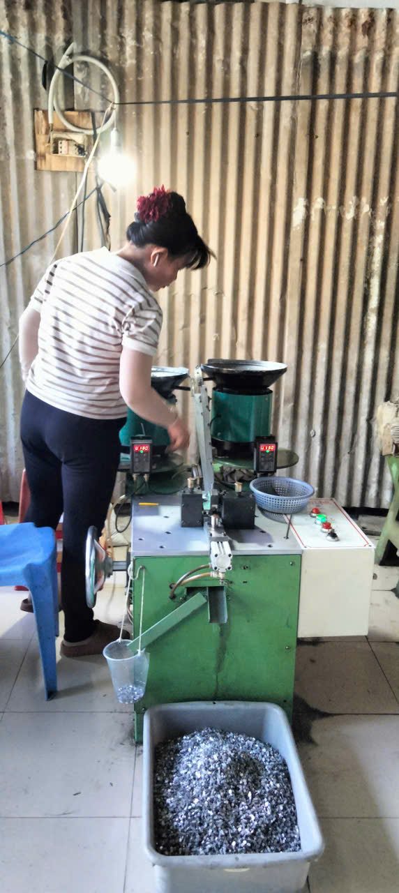 Công nhân vận hành máy xử lý răng khóa kéo tại xưởng Dương Long Công nhân vận hành máy xử lý răng khóa kéo tại xưởng Dương Long